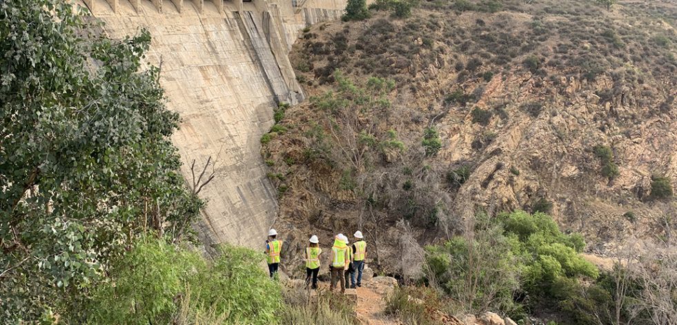 People in safety gear inspecting a dam